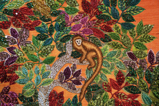 Intricate monkey embroidery on vibrant foliage background in Ind