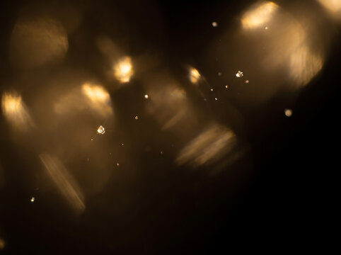 Cinematic golden light leaks and bokeh, warm amber glow with floating dust particles, elegant abstract light overlay for creative design