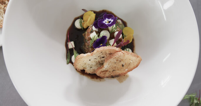 Prepared and decorated meal on white plate in kitchen, slow motion