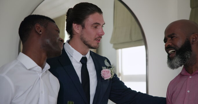 Groom reading heartfelt speech to friend holding drink at wedding reception