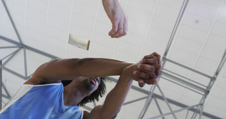 male basketball player stretching on indoor court © WavebreakMediaMicro
