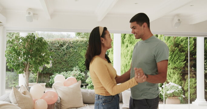 Young couple dancing joyfully at home, enjoying each other's company