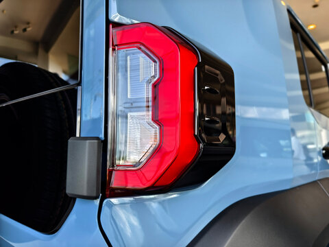 Rear corner of pickup truck with red taillight and black trim