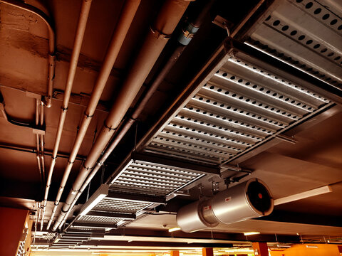 Exposed galvanized HVAC ducts and electrical conduit with bundled cables