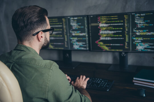 Photo of smart busy young man wear green shirt spectacles programming database writing code indoors workplace workstation