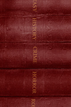 Old vintage red books with fantasy, history, crime, horror and romance genres background backdrop.