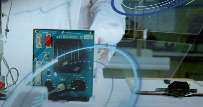 Testing technician in white coat connecting cables to blue test instrument on lab bench