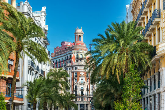 Valencia, Spain - Beautiful view of iconic historic Banco de Valencia building with its ornate Baroque regionalist architecture and palm trees under  blue sky