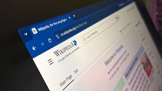 Wikipedia main page web interface on computer screen highlighting encyclopedia logo and search bar for online research concept and global knowledge digital resource.