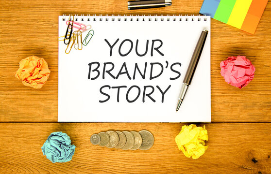 Branding and your brands story symbol. Concept words Your brands story on beautiful white note. Beautiful wooden background. Colored paper. Business branding your brands story concept. Copy space.