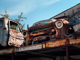 Rusty vintage pickup truck wrecks stacked in a junkyard © Filip