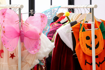 Obraz na płótnie Canvas Clothing rental store. Different festive child's costumes on rack indoors, closeup