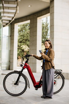 Korean woman enjoys a bright pause beside her electric bike