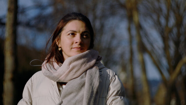 Portrait of a Caucasian woman smiling slightly in the late afternoon sun, optimism and self-assurance