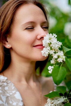Woman in a floral dress beside white garden flowers