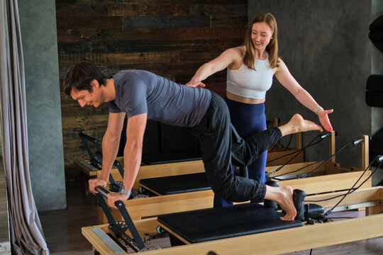 Personal trainer supporting a controlled leg extension - wide view
