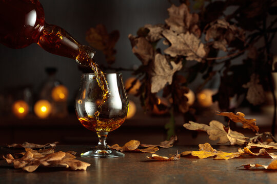 Brandy is poured from a bottle into a snifter.