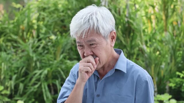 Old sick senior Asian man with white hair coughing, concept image for throat irritation, sore throat, dust allergy, allergic reaction, air pollution, polluted air, cold or flu infection