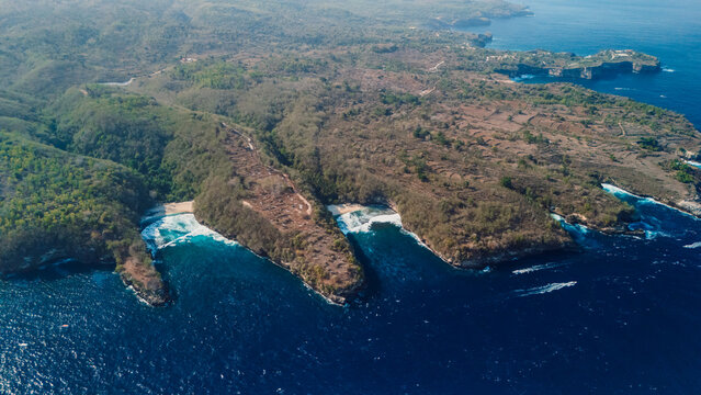 Drone view of scenic tropical bays surrounded by green hills in Nusa Penida, Bali