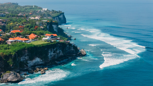 Uluwatu with cliffs, villas and surfing waves in Bali. Scenic landscape in Indonesia