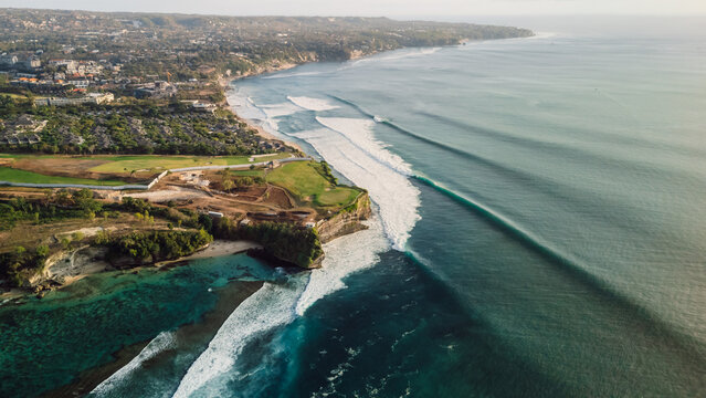 Drone view of coastline with long surfing waves. Perfect swell in Bali