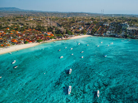 Nusa Lembongan coastline and turquoise ocean with boats, drone view