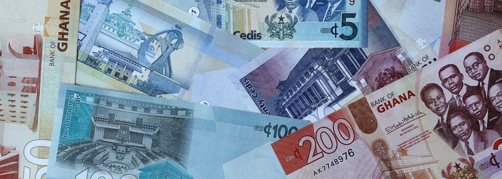 Ghanaian cedi money bills in pile on table. Ghana GHS currency banknotes background