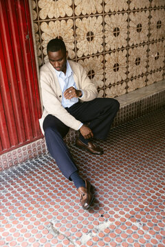 Man Seated on Patterned Tiles