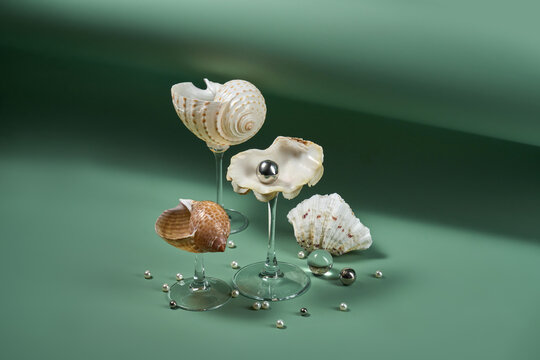 Seashells on glass stems with pearl, green concept