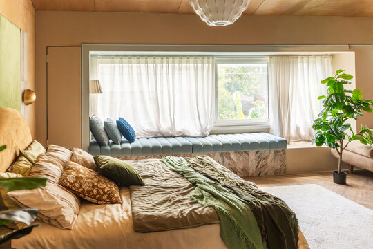Comfortable Bedroom With Seating Area by Window in Bright Space