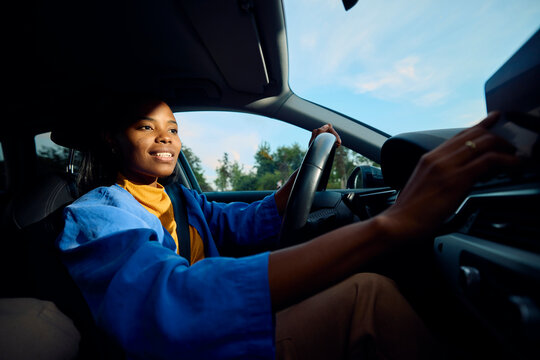 Woman drives a car, controls stereo
