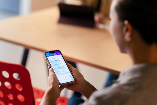 Woman Checking Calendar App on Smartphone During Meeting