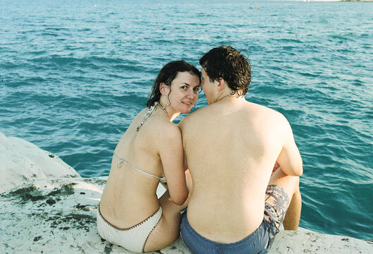 Couple Sitting Together by the Water on a Sunny Day