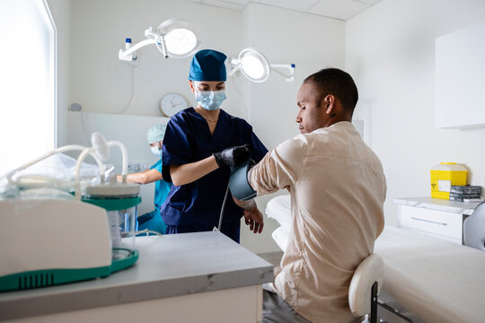 Medical professional preparing man for capillary injection procedure