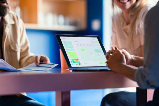 Colleagues Reviewing Schedule on Laptop During Casual Meeting