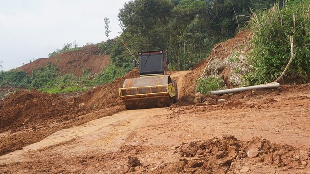 Road Roller Compactor Working on Earth Road at Construction Site in Forest Area