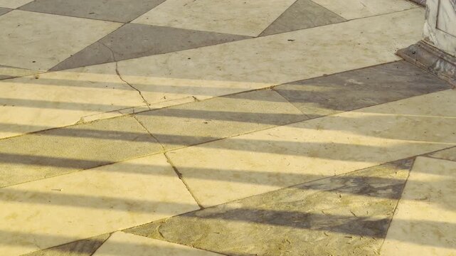 Marble balusters cast long diagonal shadows along the gallery floor in Catherine Park, Pushkin, Russia. Warm autumn sunlight fills the colonnade, evoking peaceful, tranquil feelings.