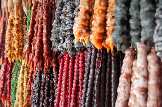 Traditional Georgian churchkhela candy hanging display. Homemade sweet nut dessert texture