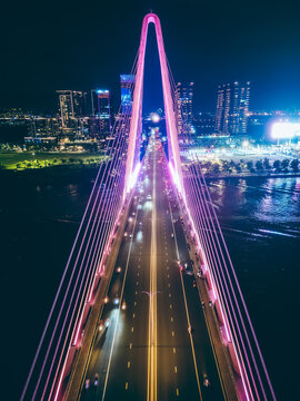 modern cable-stayed Thu Thiem suspension bridge over Saigon river with colourful illumination neon led lights, symmetric perspective and design, Ho Chi Minh city, Vietnam aerial drone view