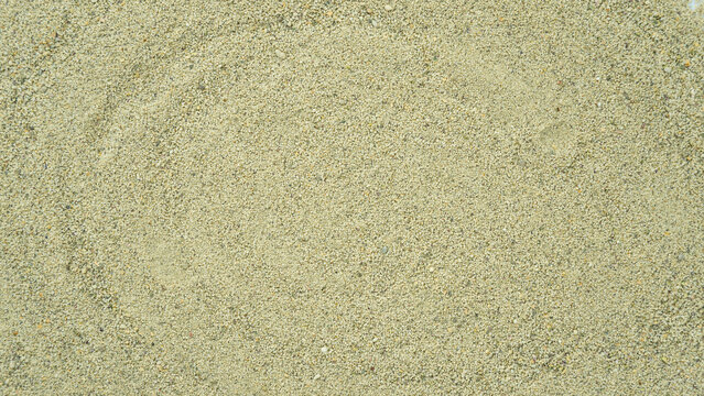 Close-up view of fine light beige sand texture, showing granular mineral particles and natural earthy surface grains in a uniform pattern