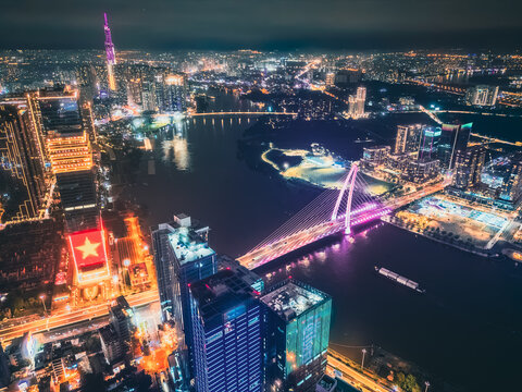 Aerial night view of Ho Chi Minh City skyline with glowing skyscrapers and neon lights, Drone panorama of Saigon downtown, illuminated towers and busy streets of vibrant city