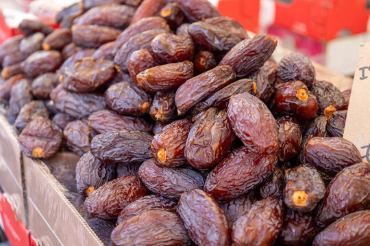 Close-up of dried medjool dates piled in a cardboard box at a market stall in Campo de' Fiori, Rome