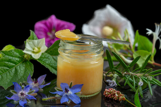 Jar of Honey With a Spoon and Flowers