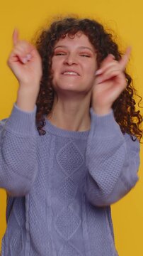 Amused curly haired woman pointing finger to camera, laughing out loud, taunting making fun of ridiculous appearance, funny joke anecdote. Young teen girl isolated alone on yellow studio background