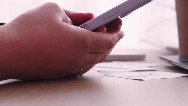 Online information. Internet work. Unrecognizable business woman specialist hands at desk using smartphone at professional workspace.