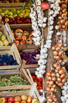 Fruit stand with fresh garlic and assorted fruits and vegetables