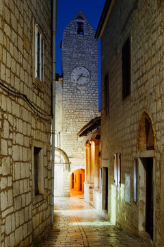 Clock tower and narrow alleyway in historic rab island, croatia