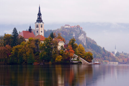 Church of assumption on lake bled island with autumn scenery