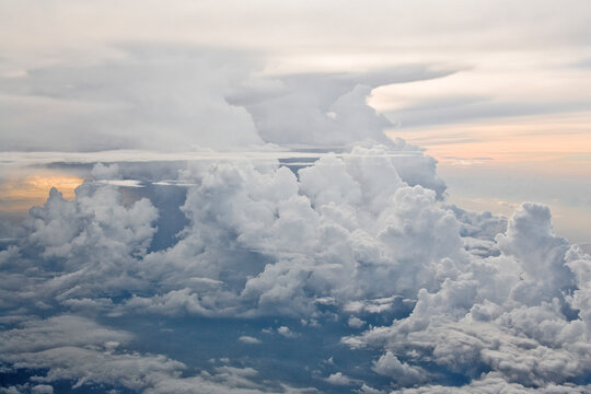 Cumulus clouds filling sky with warm sunset light