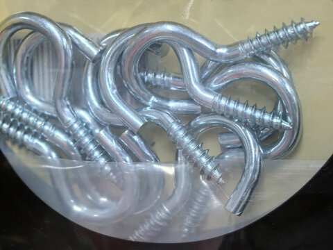 Tangled silver screw hooks gleam in a clear storage tub